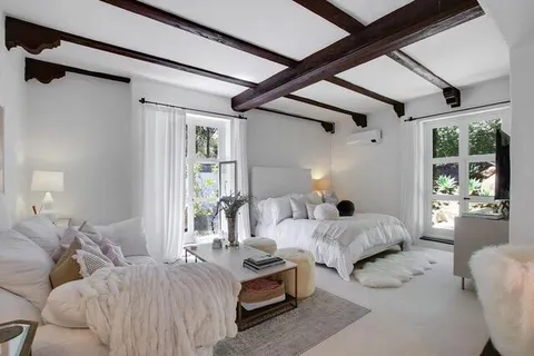 a bedroom with furniture and a large window
