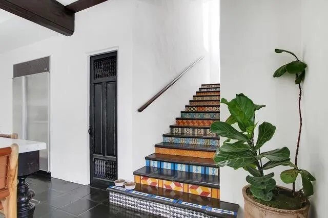 a vase of flowers sitting on a floor in front of a room