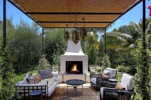 a patio with couches fire pit and outdoor seating