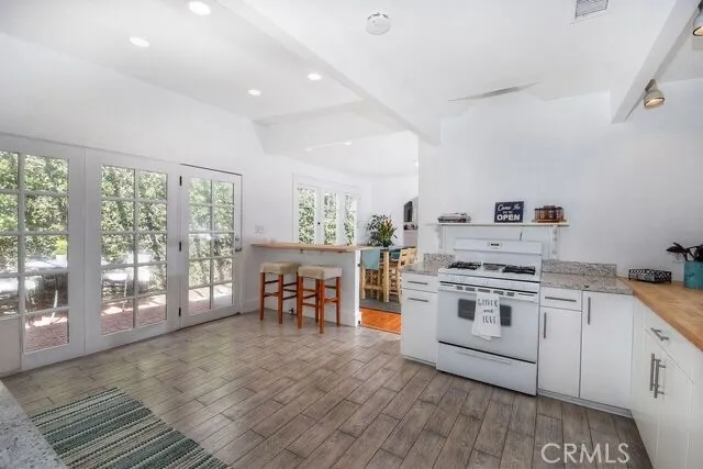 a large white kitchen with a stove a sink dishwasher and a refrigerator