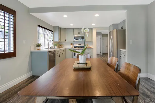 a kitchen with stainless steel appliances granite countertop a sink counter space and living room view