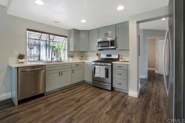 a kitchen with stainless steel appliances a white stove top oven sink and cabinets
