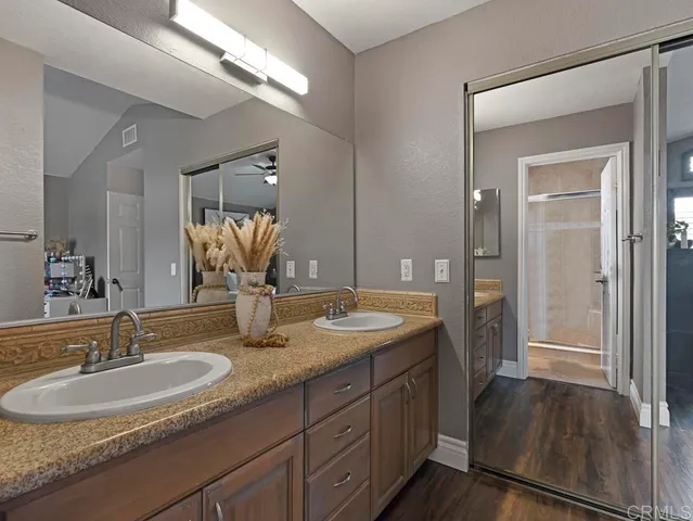 a bathroom with a granite countertop sink double vanity and a mirror