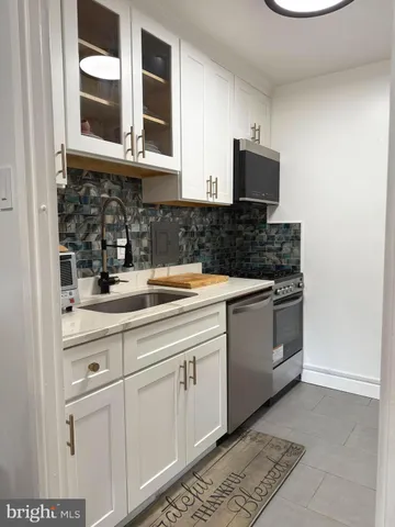 a kitchen with stainless steel appliances granite countertop a sink and a stove