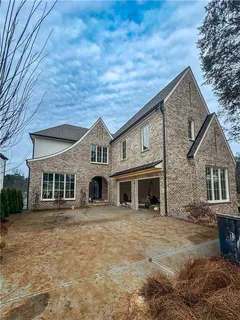 a front view of a house with large trees