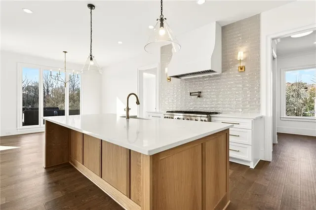 a kitchen with kitchen island a stove a sink and a refrigerator with wooden floor