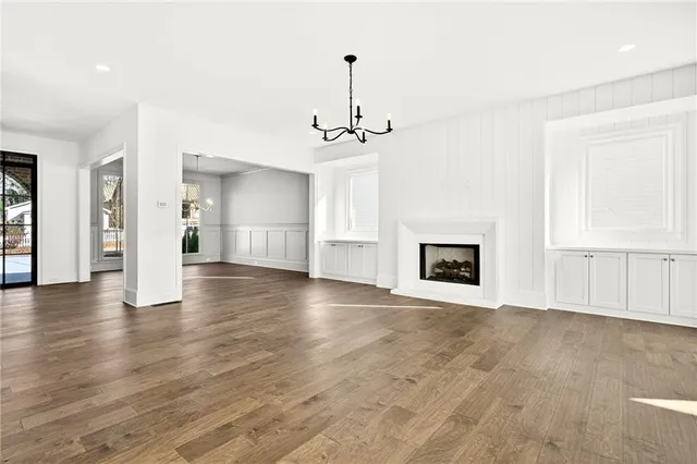 a view of an empty room with window and wooden floor