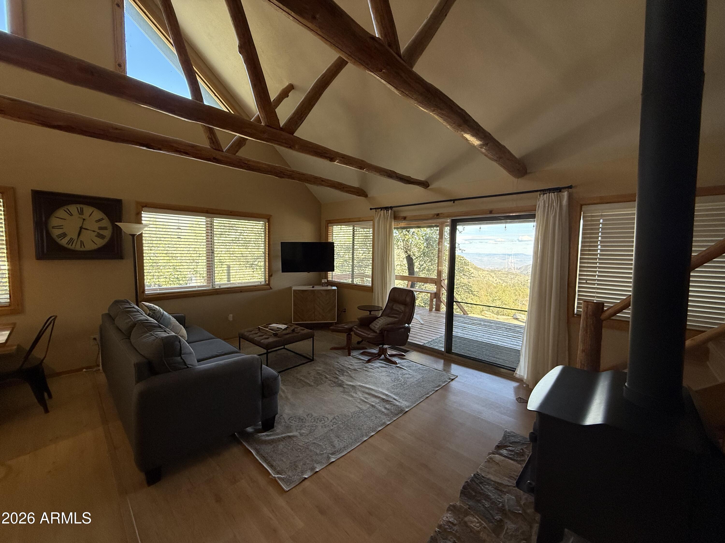 23487 Manzanita Road Crown King, AZ 86343 - Photo 26 of 45 a living room with furniture floor to ceiling window and a flat screen tv