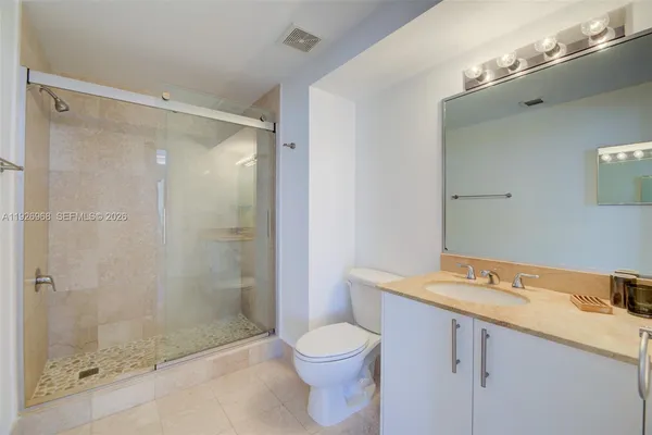 a bathroom with a granite countertop sink toilet and shower