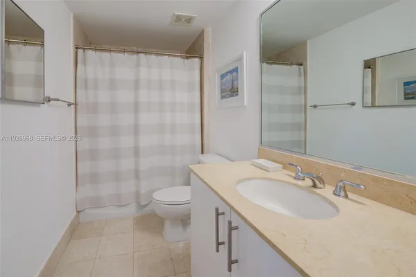 a bathroom with a sink toilet double vanity and shower