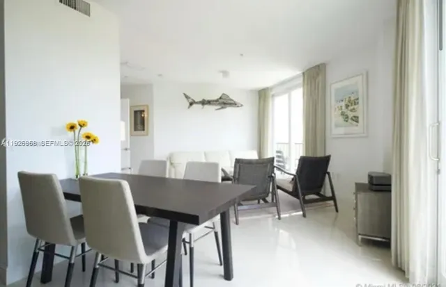 a view of a dining room with furniture and a window