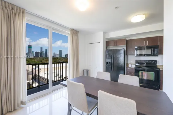 a kitchen with stainless steel appliances granite countertop a refrigerator a stove a sink dishwasher with a dining table and chairs