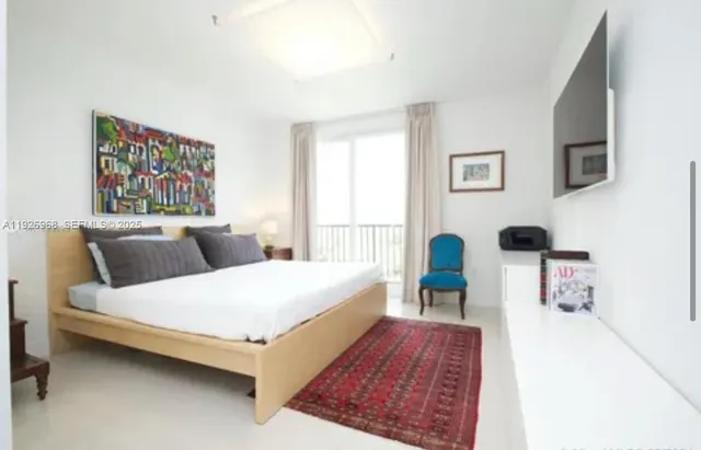 a bedroom with a bed and a large window