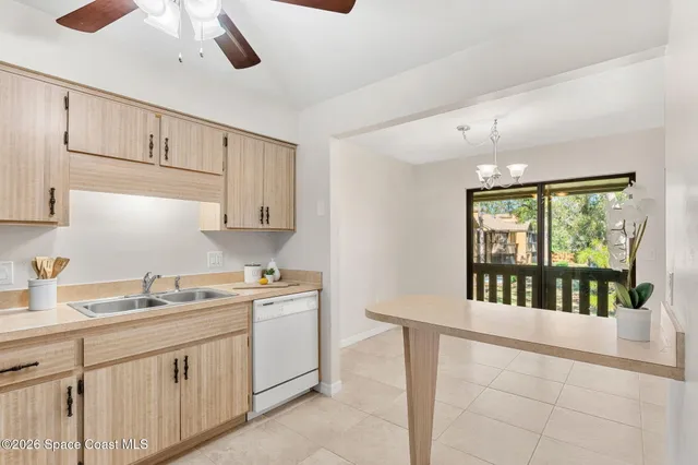 a kitchen with stainless steel appliances a refrigerator a stove a sink a stove a dining table and chairs with wooden floor