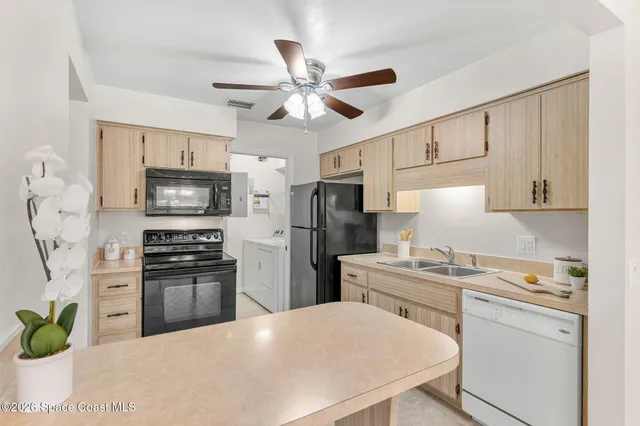 a view of a kitchen with a sink cabinets and stainless steel appliances