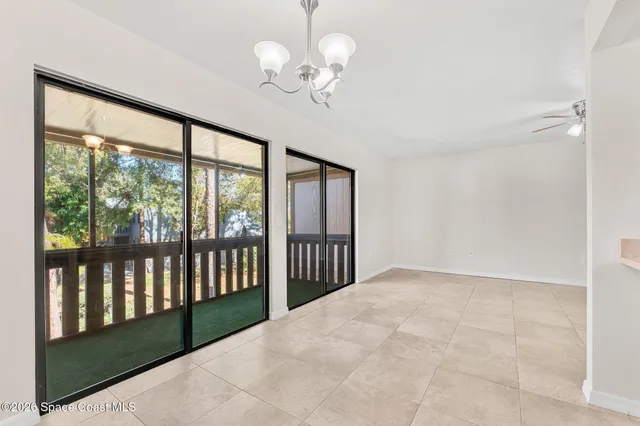 an empty room with windows and ceiling fan
