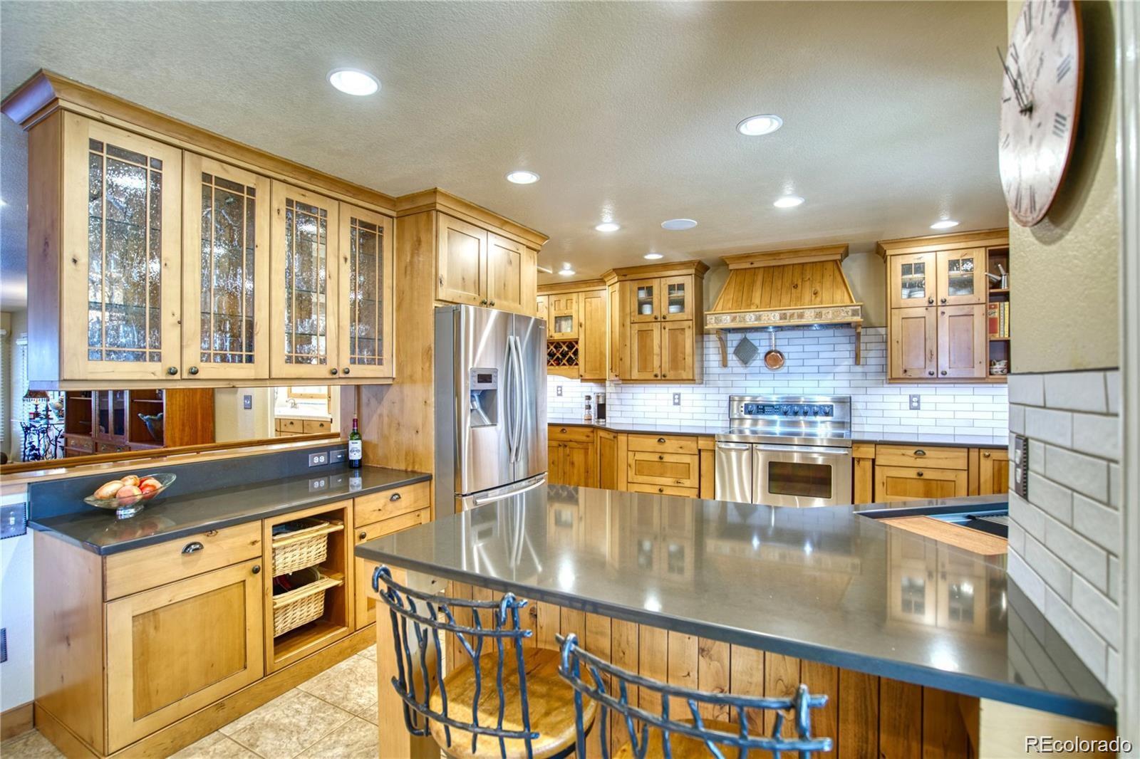 a kitchen with stainless steel appliances granite countertop a refrigerator a stove and a wooden cabinets