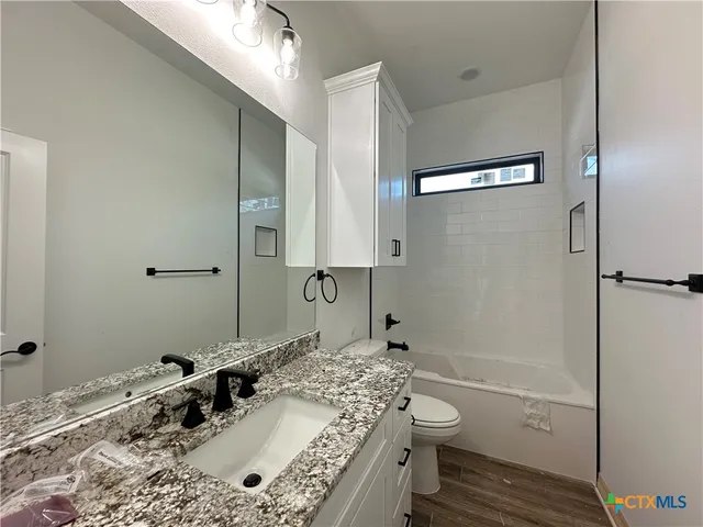 a bathroom with a sink and mirror with toilet