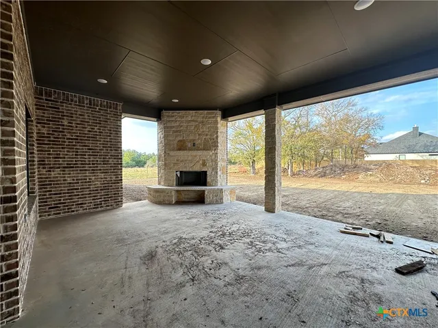 a view of an empty room with a fireplace and large windows