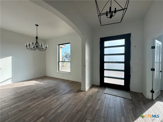 a view of empty room with wooden floor and window