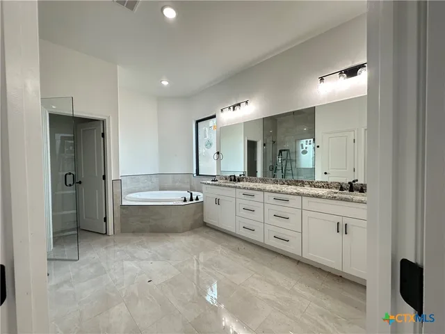a spacious bathroom with a granite countertop sink mirror and shower