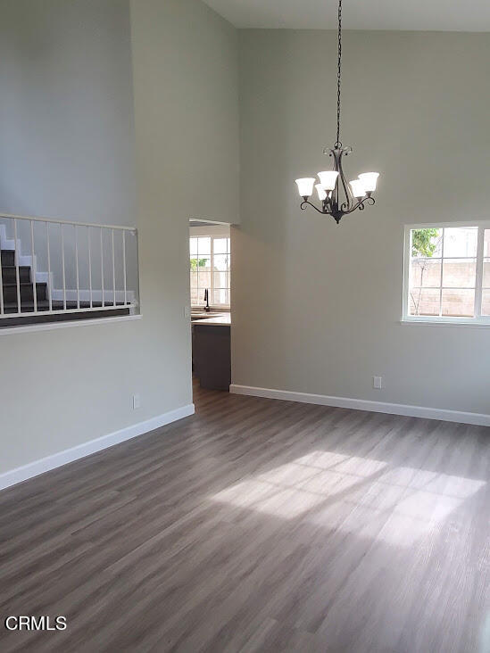 410 Bluebell Place Oxnard, CA 93036 - Photo 11 of 20 an empty room with wooden floor chandelier and windows