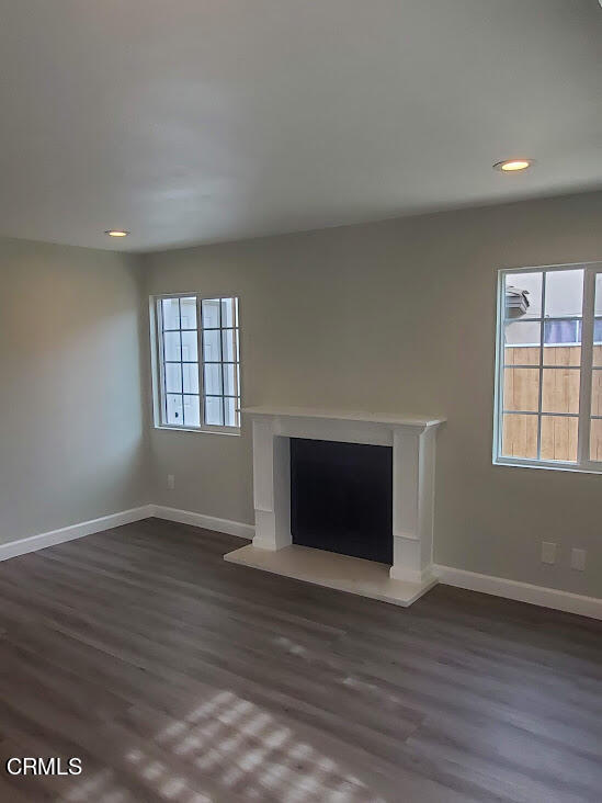 410 Bluebell Place Oxnard, CA 93036 - Photo 2 of 20 an empty room with wooden floor fireplace and windows