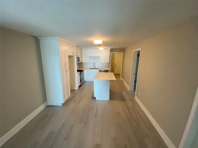 a view of a kitchen with a sink and refrigerator