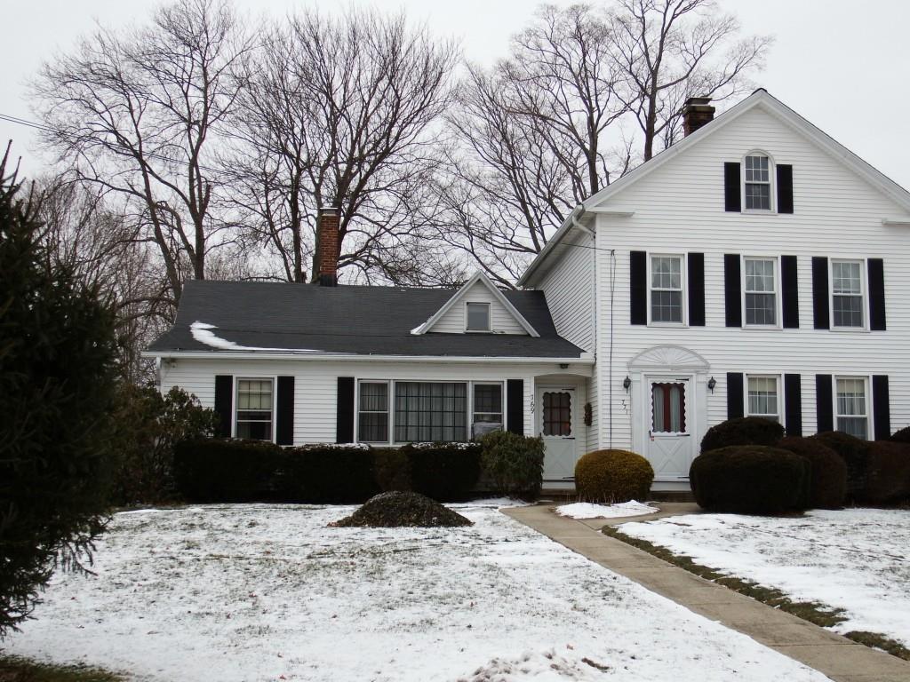 a front view of a house with a yard covered in snow