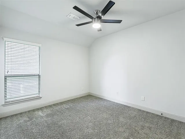 an empty room with a window and a ceiling fan