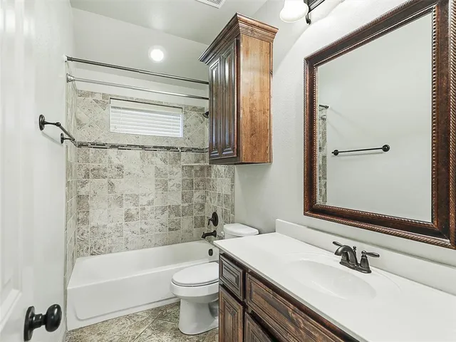 a bathroom with a sink a toilet a mirror and bathtub