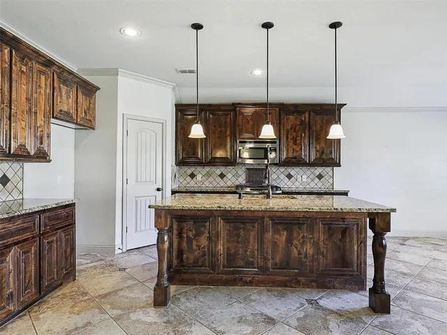 a kitchen with a sink a counter space appliances and cabinets