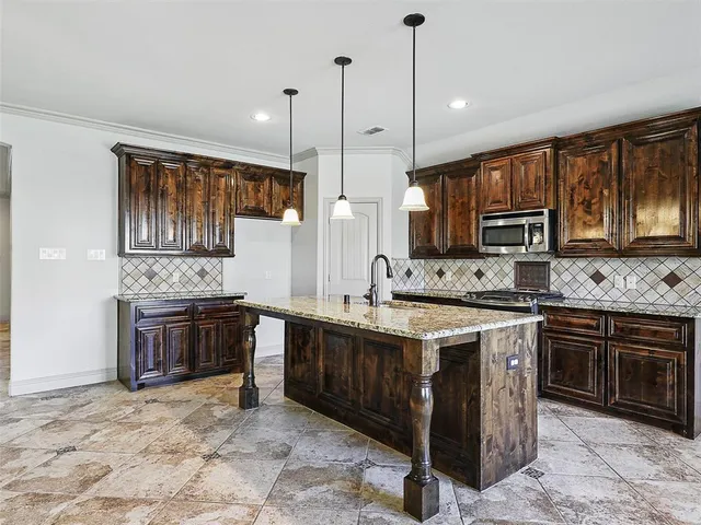 a large kitchen with stainless steel appliances granite countertop a stove sink and microwave
