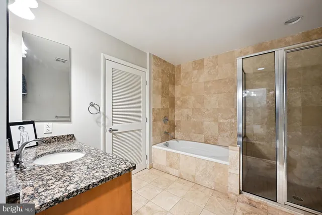 a bathroom with a granite countertop sink and a mirror