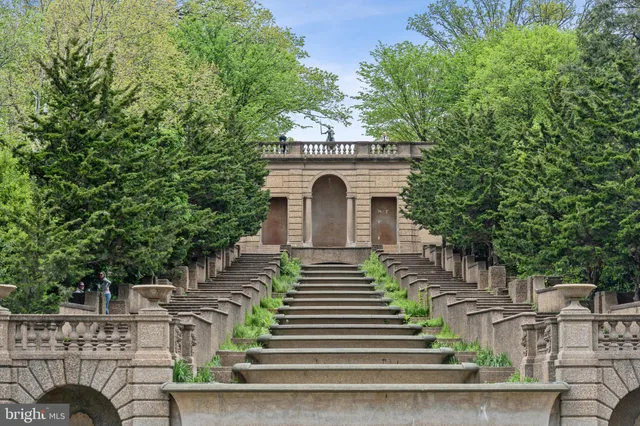 a backyard of a house with lots of green space and fountain