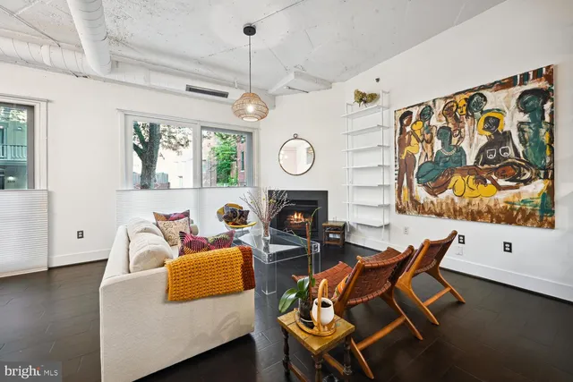 a living room with fireplace furniture and a wooden floor