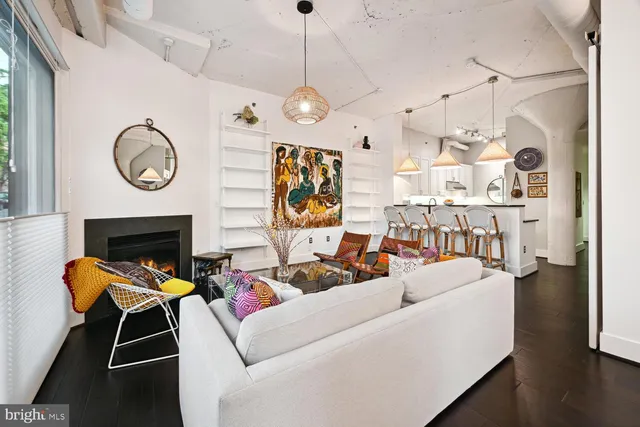 a living room with furniture a fireplace and a chandelier