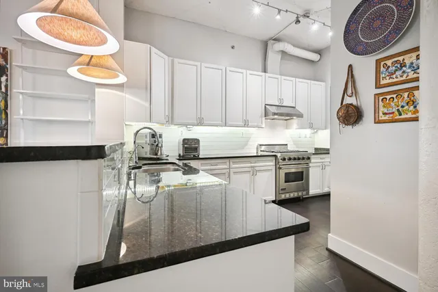 a kitchen with stainless steel appliances granite countertop a sink a stove and a refrigerator