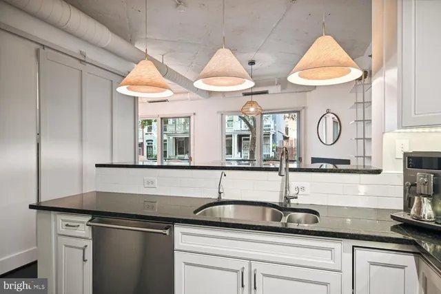 a kitchen with stainless steel appliances granite countertop a sink and a stove