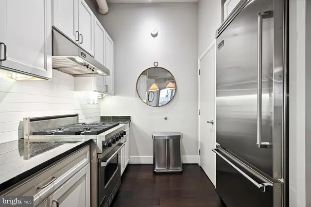 a kitchen with stainless steel appliances granite countertop a stove and a refrigerator