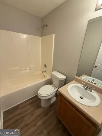 a view of a room with wooden floor and fan