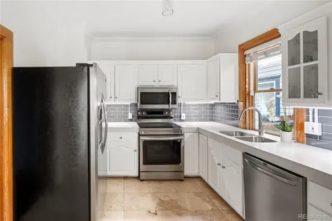 a kitchen with granite countertop white cabinets and a sink