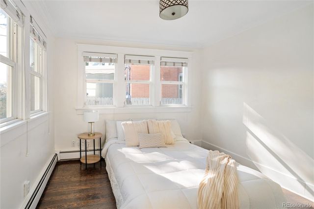 a view of a hallway with wooden floor and a bathroom