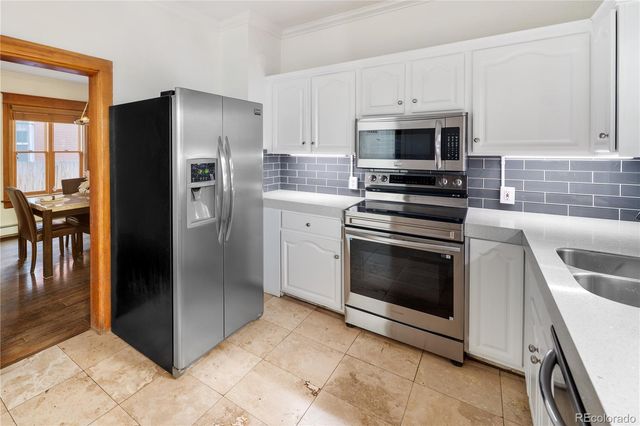 a kitchen with granite countertop a stove microwave and refrigerator