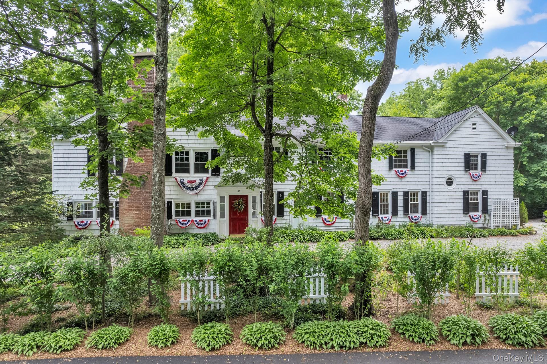 a front view of a house with a yard and potted plants