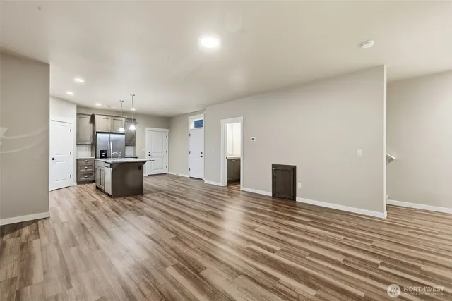 a kitchen with stainless steel appliances wooden floor and large windows