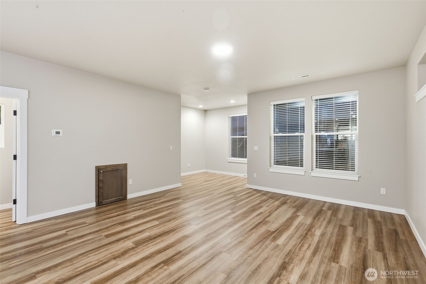 7110 South 13th Street Ridgefield, WA 98642 - Photo 8 of 28 a view of an empty room with wooden floor and a window
