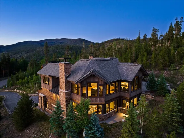 a front view of a house with a yard and mountain