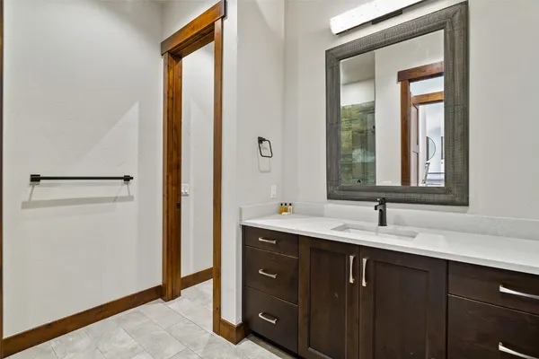 a bathroom with a double vanity sink and mirror with window