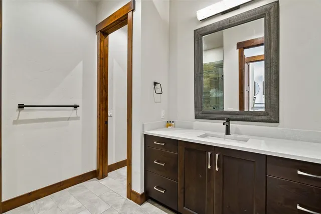 a bathroom with a double vanity sink and mirror with window